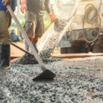 Group,Of,Construction,Workers,Are,Laying,Down,Concrete.,One,Of