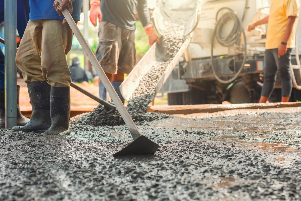 Group,Of,Construction,Workers,Are,Laying,Down,Concrete.,One,Of