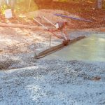 Worker,On,Building,Site,Are,Leveling,Concrete,For,Driveway,With